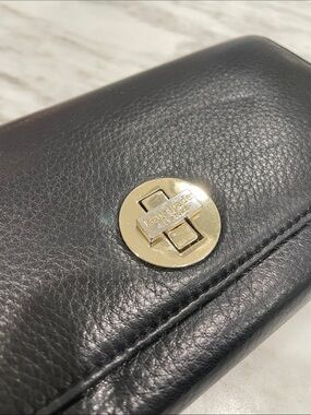 kate spade black leather wallet with gold circular turn-lock